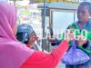 Owner Nasi Tempong Tiga Cabe, Sutini Kasong menyerahkan paket Nasi Tempong yang diorder pelanggan menggunakan aplikasi pesan antar Gojek.