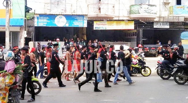 Ormas Suku Tolaki arak-arakan sambil membawa parang 'Taawu'dalam aksi pawai budaya, Kamis (16/12/2021).