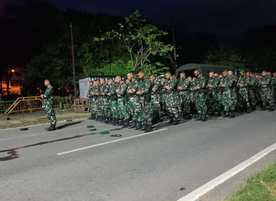 Disela pengamanan aksi bentrok antarormas, personil TNI menggelar salat jamaah di Kebi.