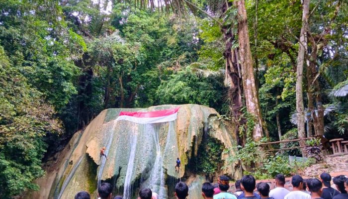 Bendera Merah Putih Sepanjang Delapan Meter Berkibar di Tebing Air Terjun Tirta Rimba Baubau 